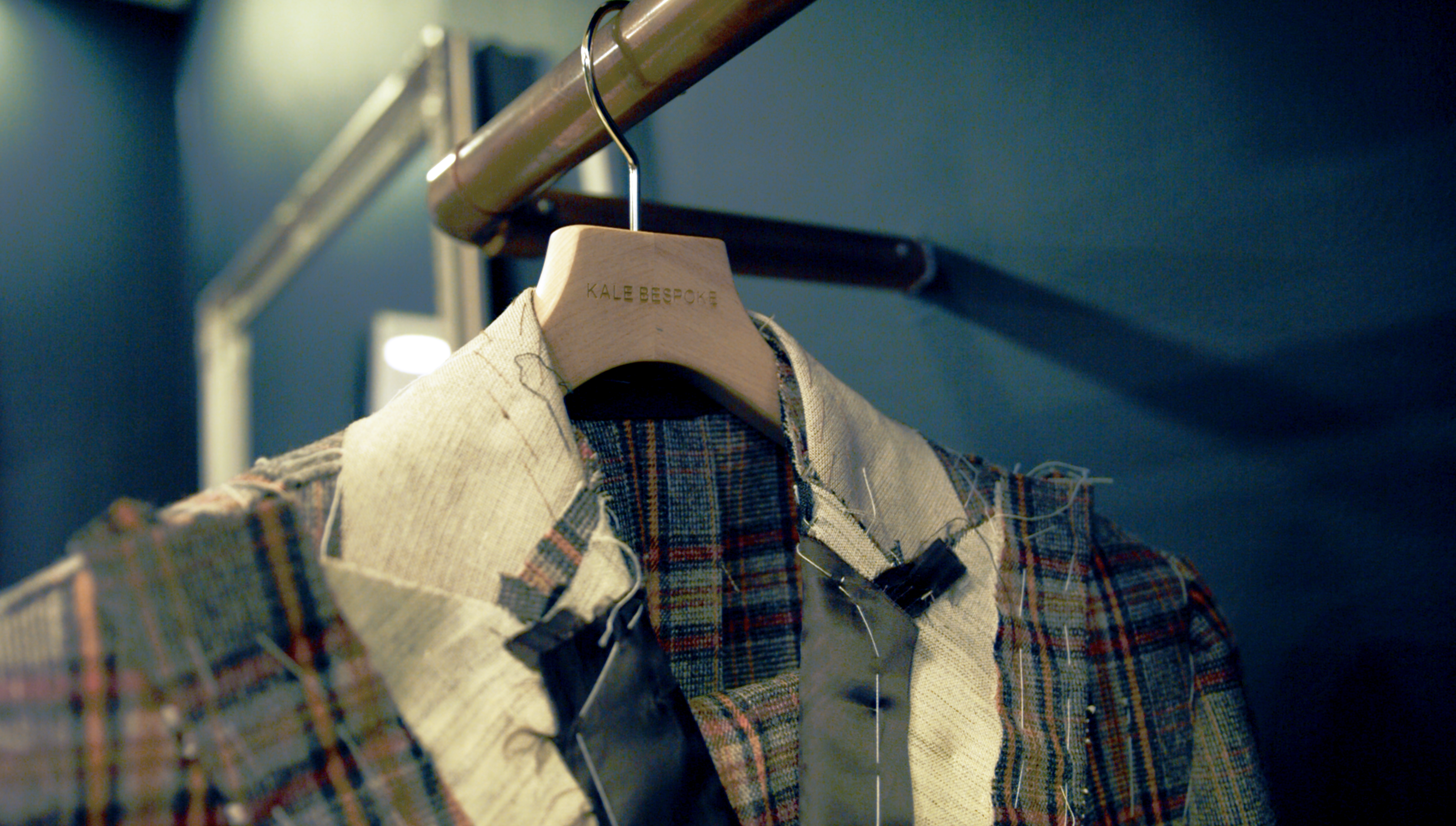 Bespoke tailored jacket at baste stage on hanging rail