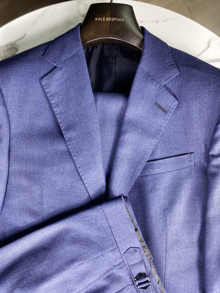 men's blue bespoke suit on hanger