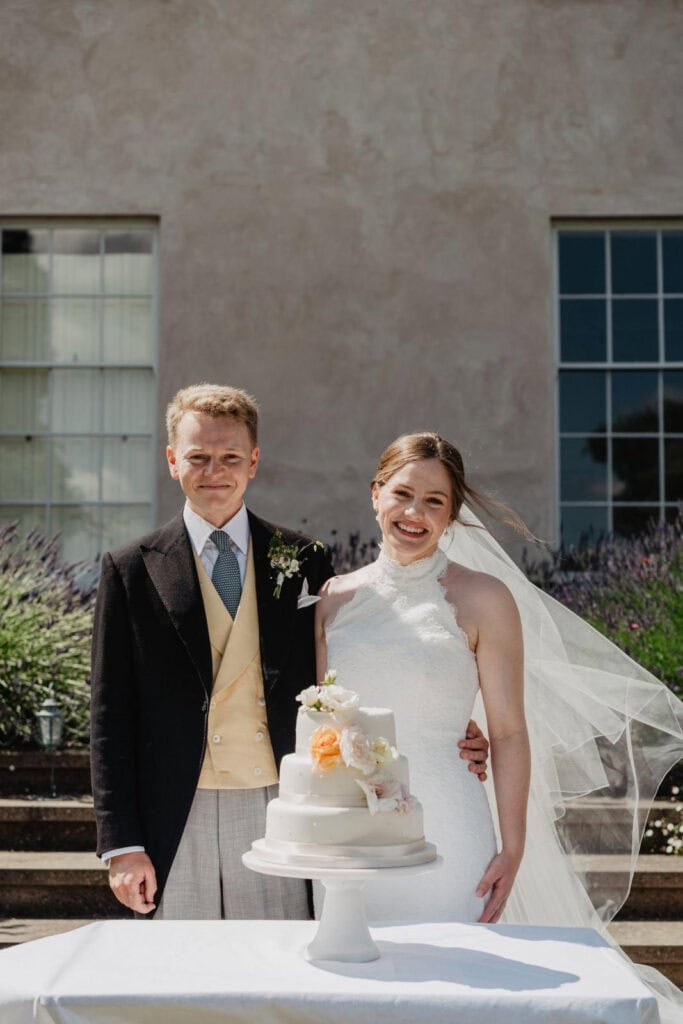 bride with groom in bespoke morning suit with yellow waistcoat